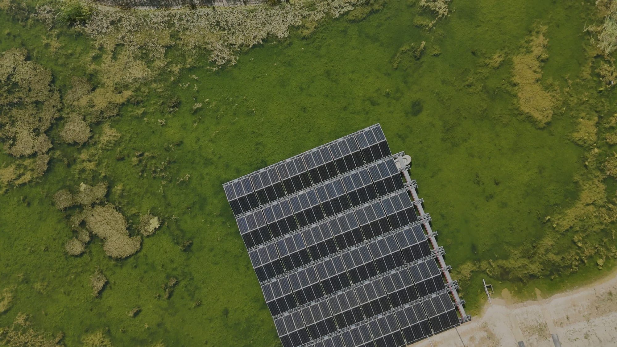Drönarbild av flytande solceller på en damm